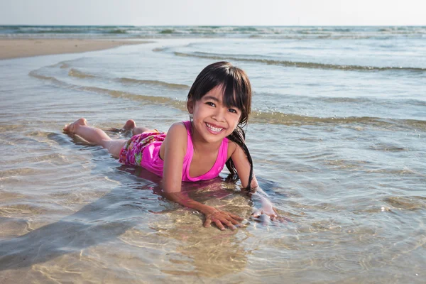 Liten flicka som leker på stranden — Stockfoto