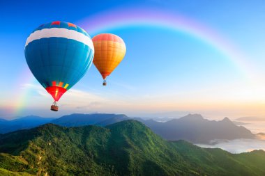 Dağların üzerinde uçan renkli sıcak hava balonları