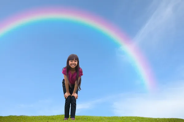 Sorridente asiatica bambina in piedi su erba verde sotto la pioggia — Foto Stock