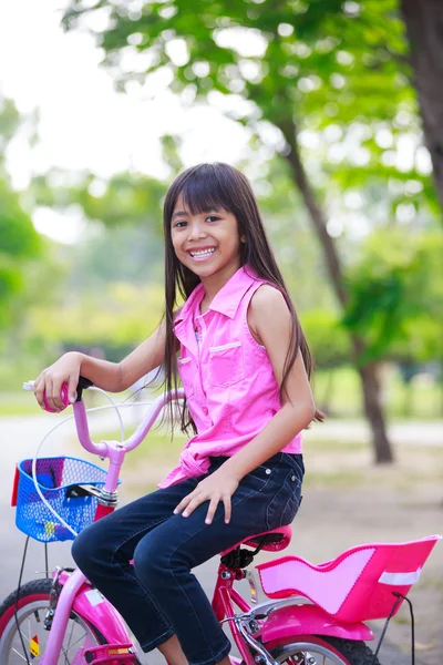 Asiatiska liten flicka på cykel i parken — Stockfoto