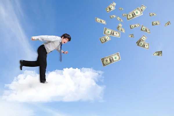 Młody biznes człowiek działa na chmury na niebie — Zdjęcie stockowe