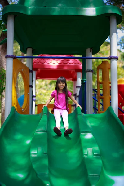 Smiling asian little girl sitting slide — Stock Photo, Image