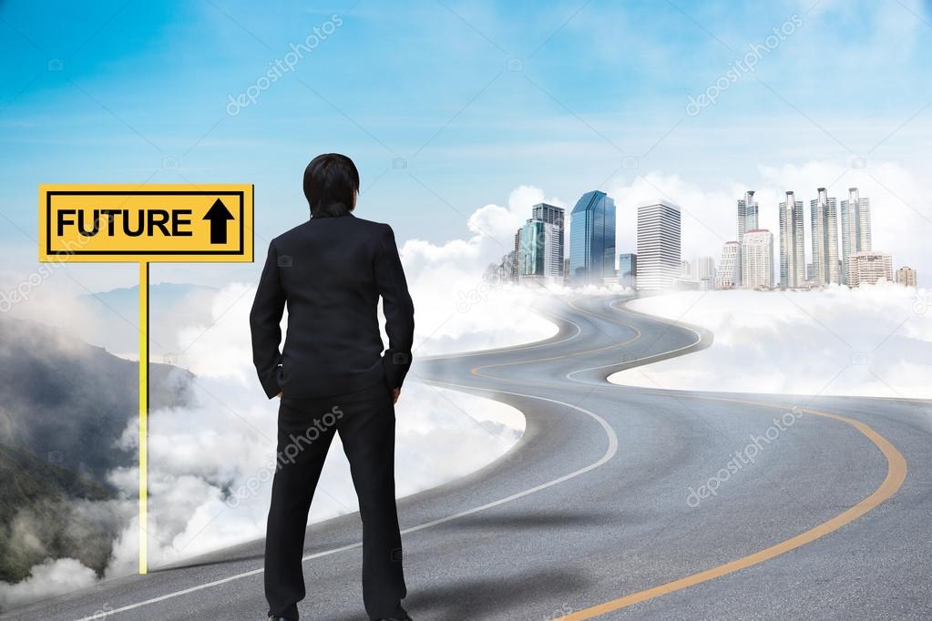 Businessman standing on the empty road and watching the future c