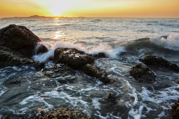 Havet våg slå berget vid solnedgången — Stockfoto