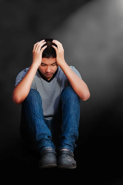 Traurige asiatische Teenager Junge sitzt auf dem Fußboden — Stockfoto