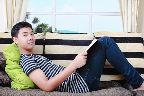 Teenager asian boy laying on sofa — Stock Photo, Image