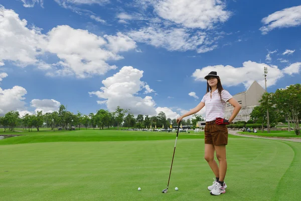 Jovem mulher jogando golfe em um campo de golfe verde — Fotografia de Stock