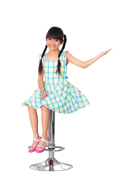 Happy little asian girl sitting on high chair — Stock Photo, Image