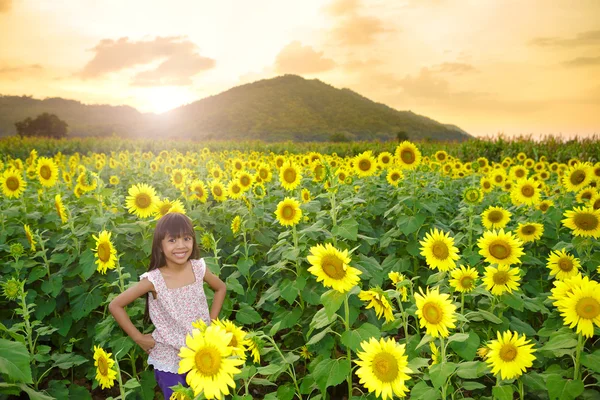 Primer plano chica sonriente en el campo de girasoles —  Fotos de Stock