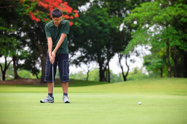 Golf adolescente chico jugador verde putting — Foto de Stock