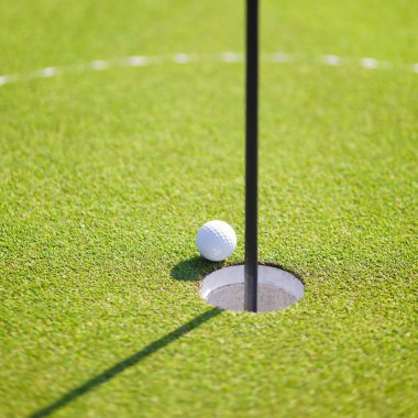 Golf ball on lip of cup