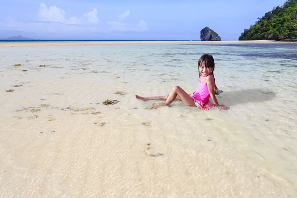 Pequeña chica asiática sentada en playa tropical —  Fotos de Stock