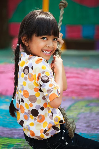 Asian little girl enjoys playing in a children playground — Stock Photo, Image