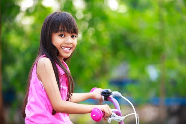 Маленькая азиатка на велосипеде — стоковое фото