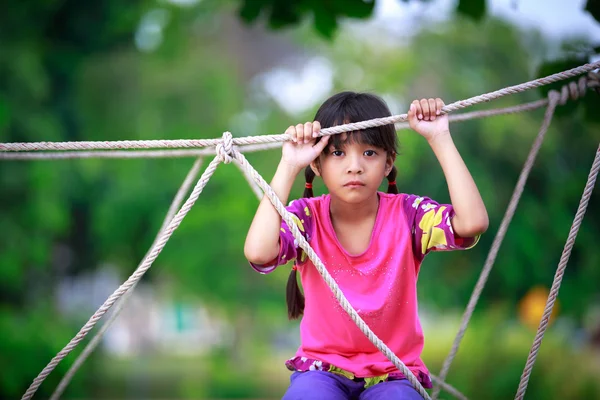 Traurige kleine asiatische Mädchen sitzen allein auf einem Spielplatz — Stockfoto