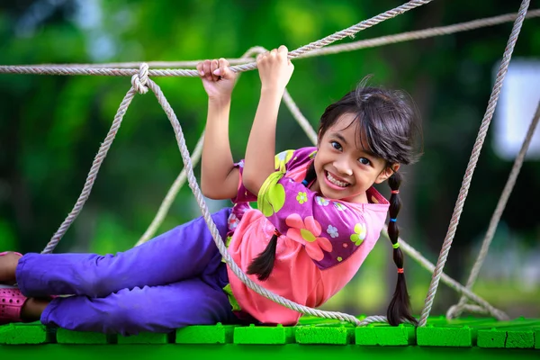 Felice piccola ragazza asiatica sul parco giochi — Foto Stock