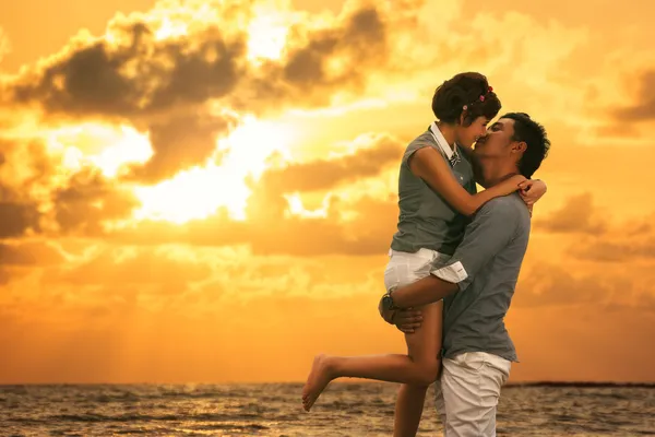 Jovem asiático casal no amor ficar e beijar na praia — Fotografia de Stock