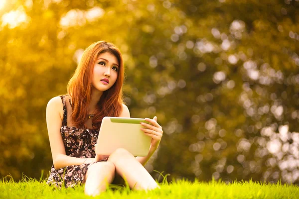 Asian woman using digital tablet in park — Stock Photo, Image