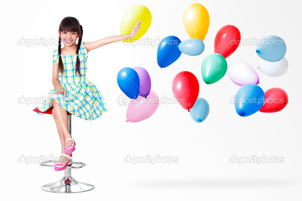 Smiling little asian girl sitting with balloons