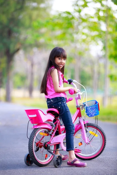 Onu pembe bisiklet üzerinde şirin Asyalı kız — Stok fotoğraf