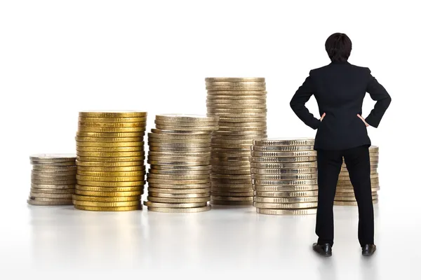 Uomo d'affari in piedi con pila di monete — Foto Stock