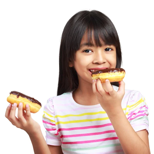 Little asian girl holding and eating chocolate donuts — Stock Photo, Image