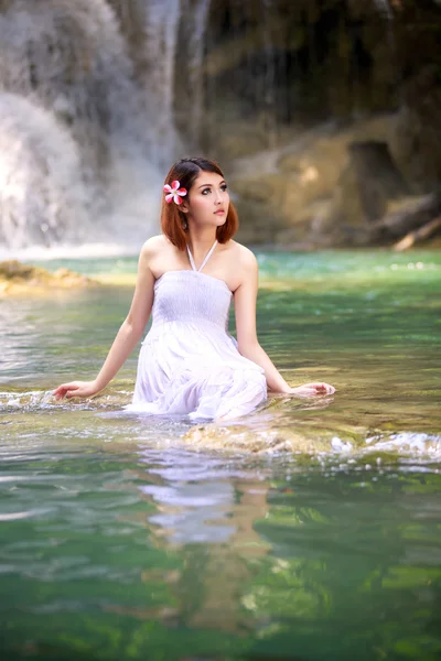 Mujer joven relajándose en el arroyo de agua cerca de la cascada —  Fotos de Stock