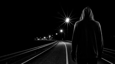 Teenager boy standing alone in the street at night