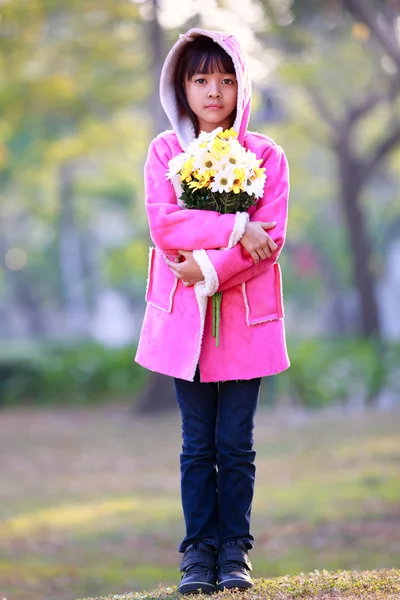 Ledsen liten asiatisk tjej håller en bukett blommor — Stockfoto