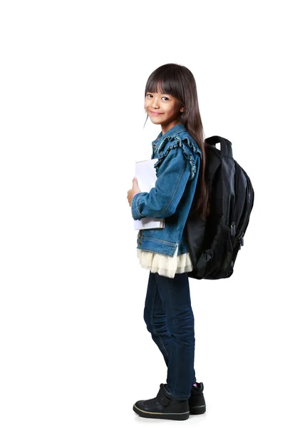 Kleines asiatisches Mädchen steht und hält Bücher — Stockfoto