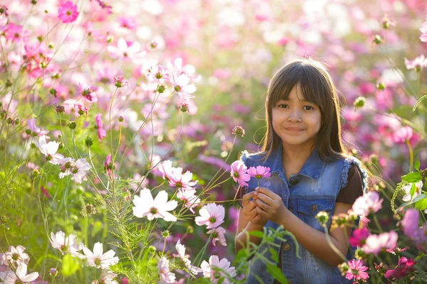 Маленька азіатська дівчинка в квіткових полях — стокове фото