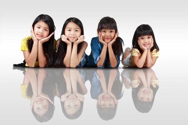 躺在地板上的四个快乐小亚洲女孩 — 图库照片