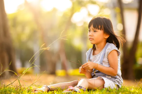 庭の芝生の上の小さなアジアの女の子 — ストック写真