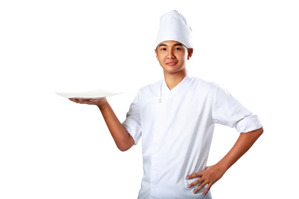 Młody kucharz trzyma pustej płyty z kciukiem — Zdjęcie stockowe