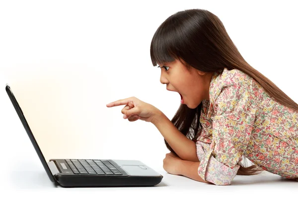 Chica sorprendida señalando a la computadora — Foto de Stock
