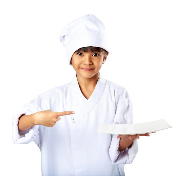 Pouco asiático menina chef mostrando o vazio branco prato — Fotografia de Stock