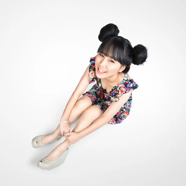 Smiling teenage asian girl sitting on the floor — Stock Photo, Image