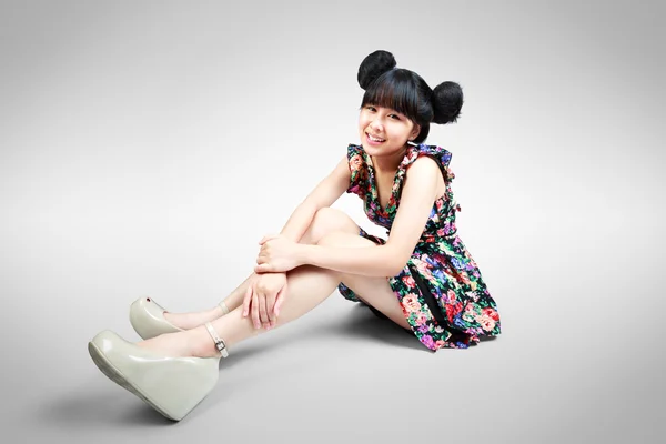 Smiling teenage asian girl sitting on the floor — Stock Photo, Image