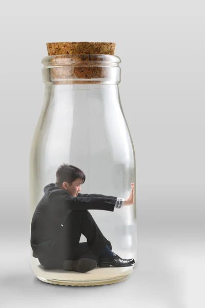 Young businessman trapped in a glass jar — Stock Photo, Image