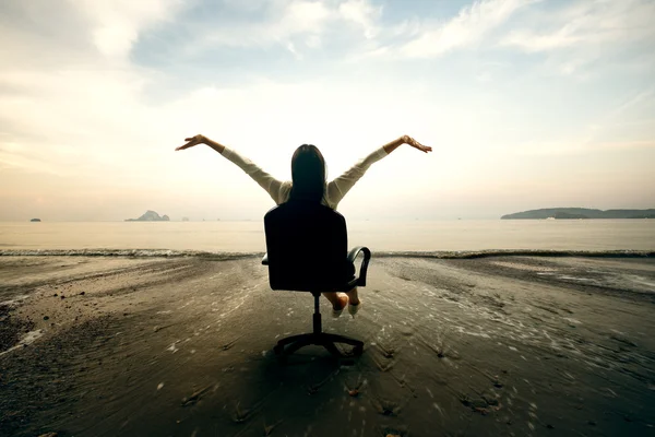 Sahilde oturmuş rahatlatıcı bir iş kadını