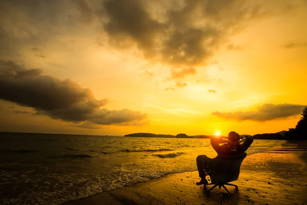 Avkopplande affärsman som sitter på stranden — Stockfoto