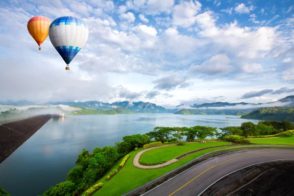 Hot air balloon ffloating over dam — Stock Photo, Image
