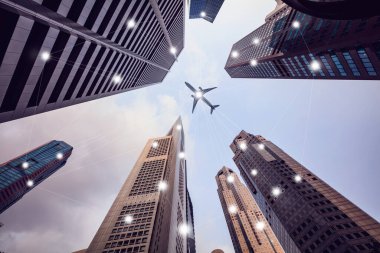 Uzun şehir binaları ve tepemizde uçan bir uçak, Smartcity wiht Technology Taşımacılık konsepti