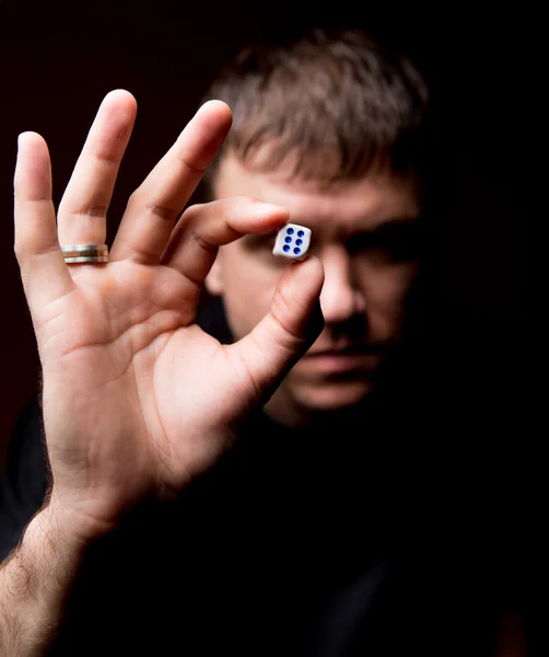 Man carefully considers the dice — Stock Photo, Image