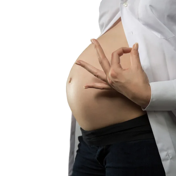 Mujer embarazada haciendo OK signo y señalando su campana — Foto de Stock