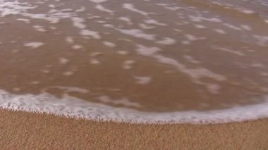 zee Golf veegt vlakke strand zand