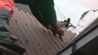 man op de ladder hameren dak blad