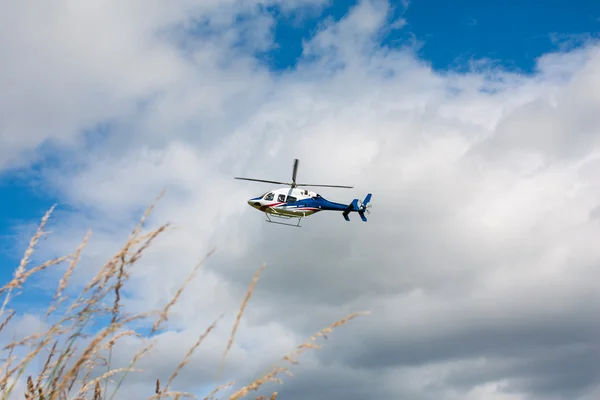 beyaz mavi kırmızı boyalı helikopter uçuş