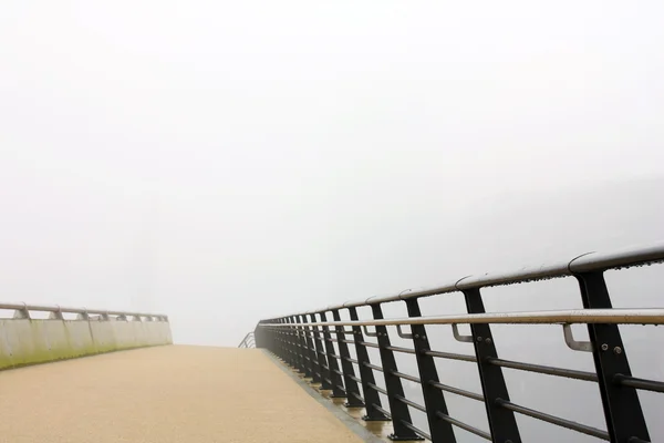 Puente peatonal en una niebla pesada Fotos de stock