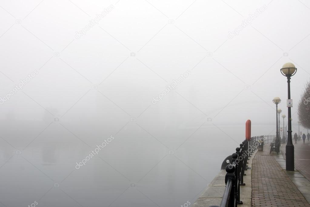 People on a quayside in mist